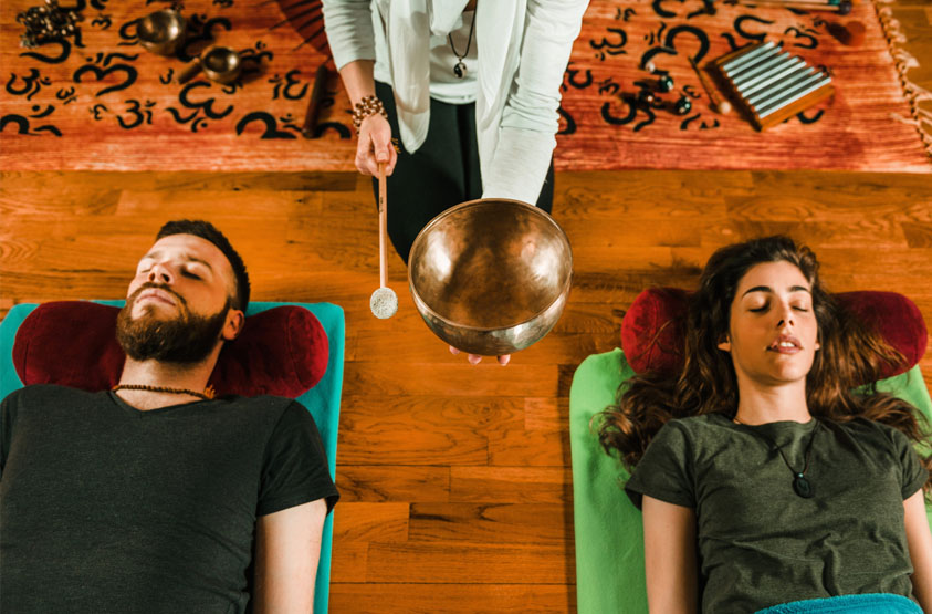 Couple doing singing bowl healing meditation together
