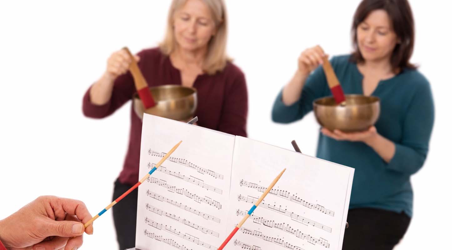 Musician finding the perfect singing bowl note using Tibetan singing bowl for sound healing meditation and tuning