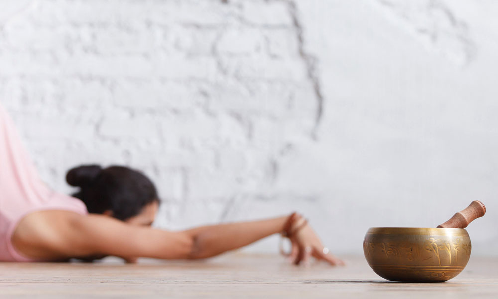 Use of singing bowls in yoga practice to support relaxation, breath, and mindful awareness