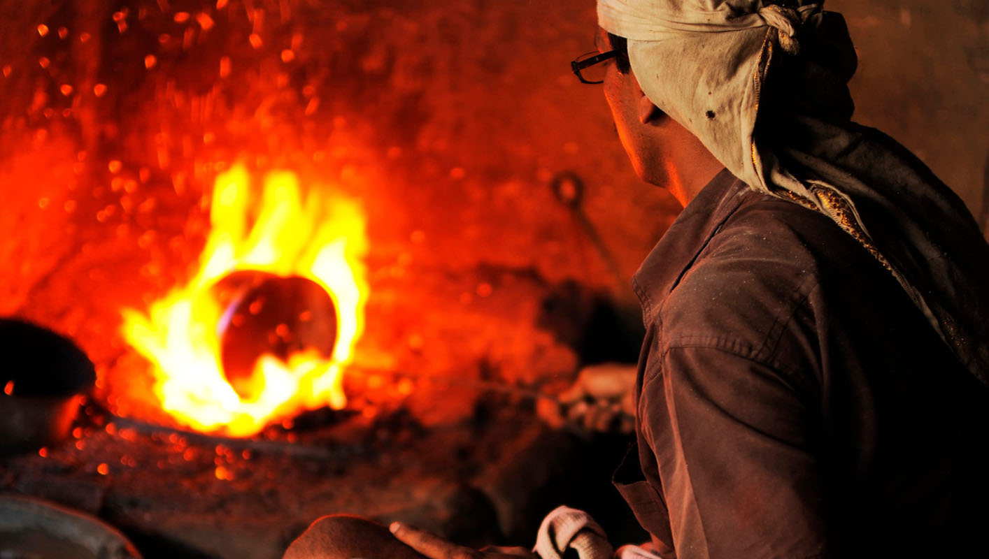 Reheating metal during Tibetan singing bowl making process before hammering