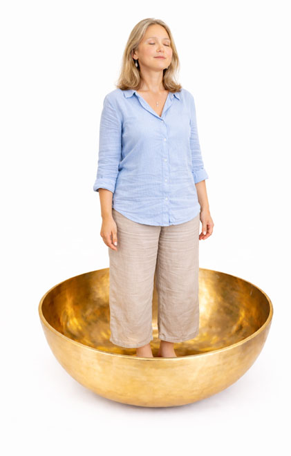 woman standing inside large standing singing bowl meditation sound healing grounding Tibetan bowl